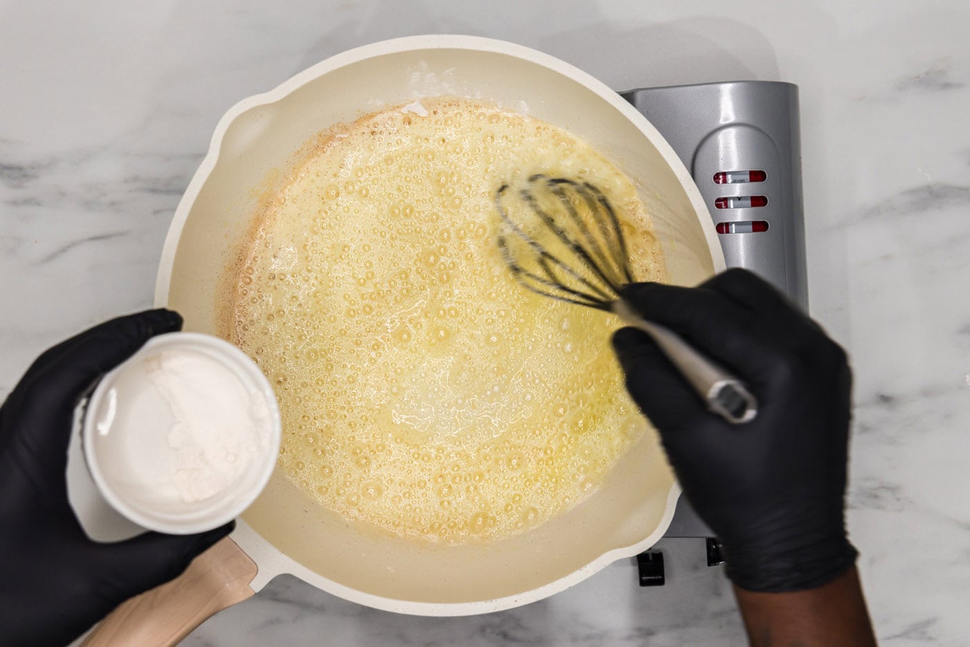 whisking flour into melted butter in a skillet