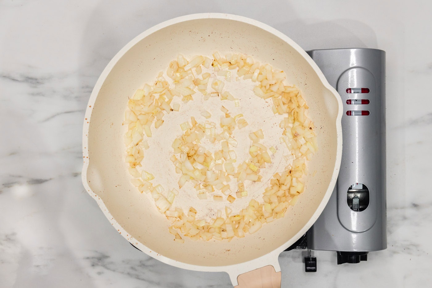 sauteeing chopped onion in a skillet