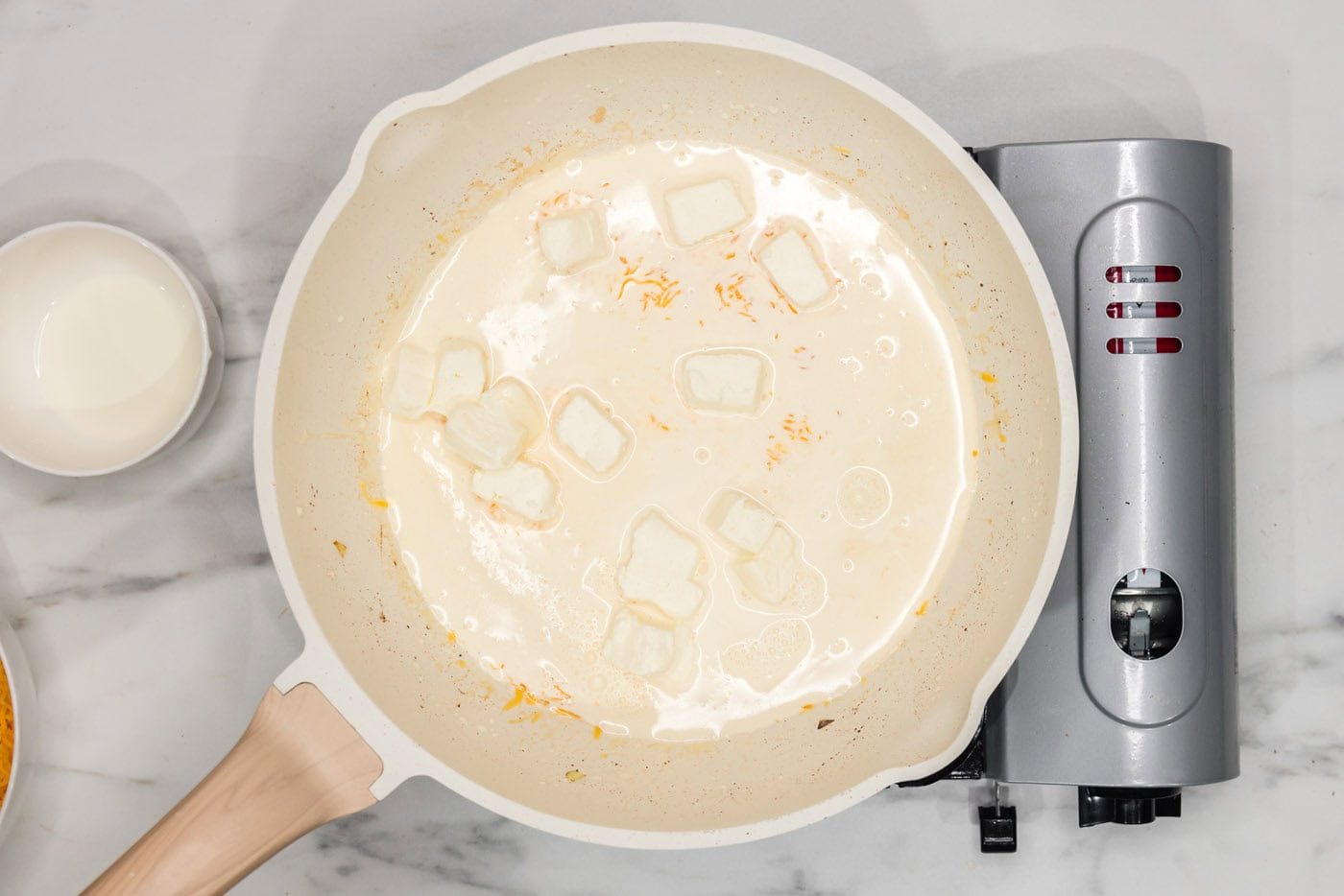 cream cheese in a skillet with heavy cream and onions