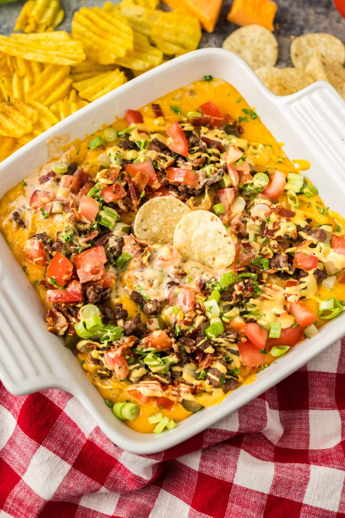 Dish of Cheeseburger Dip with two chips in it