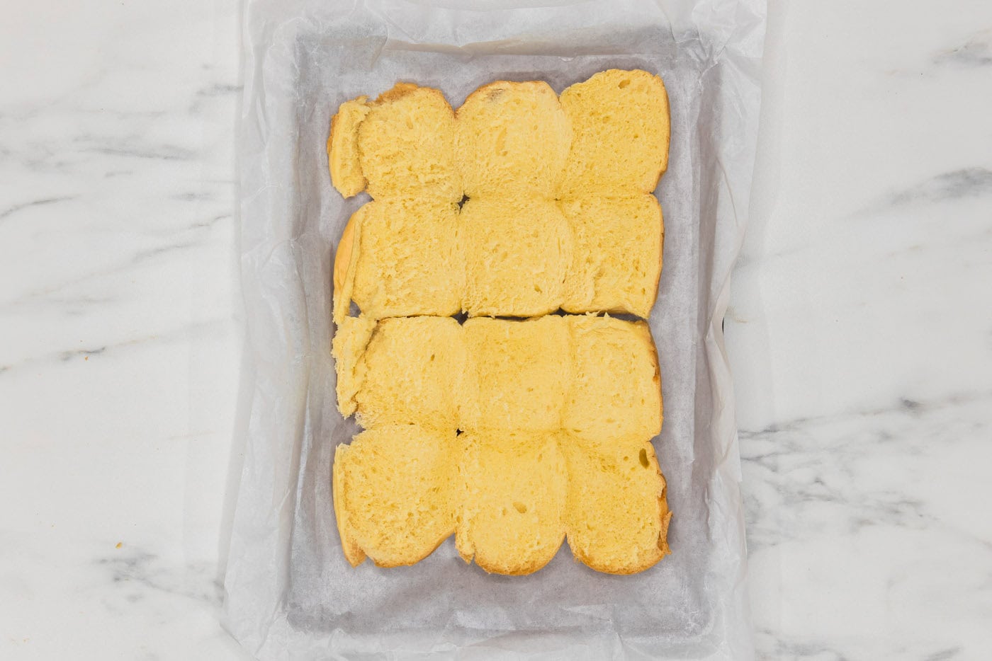 slider buns in a parchment lined baking dish