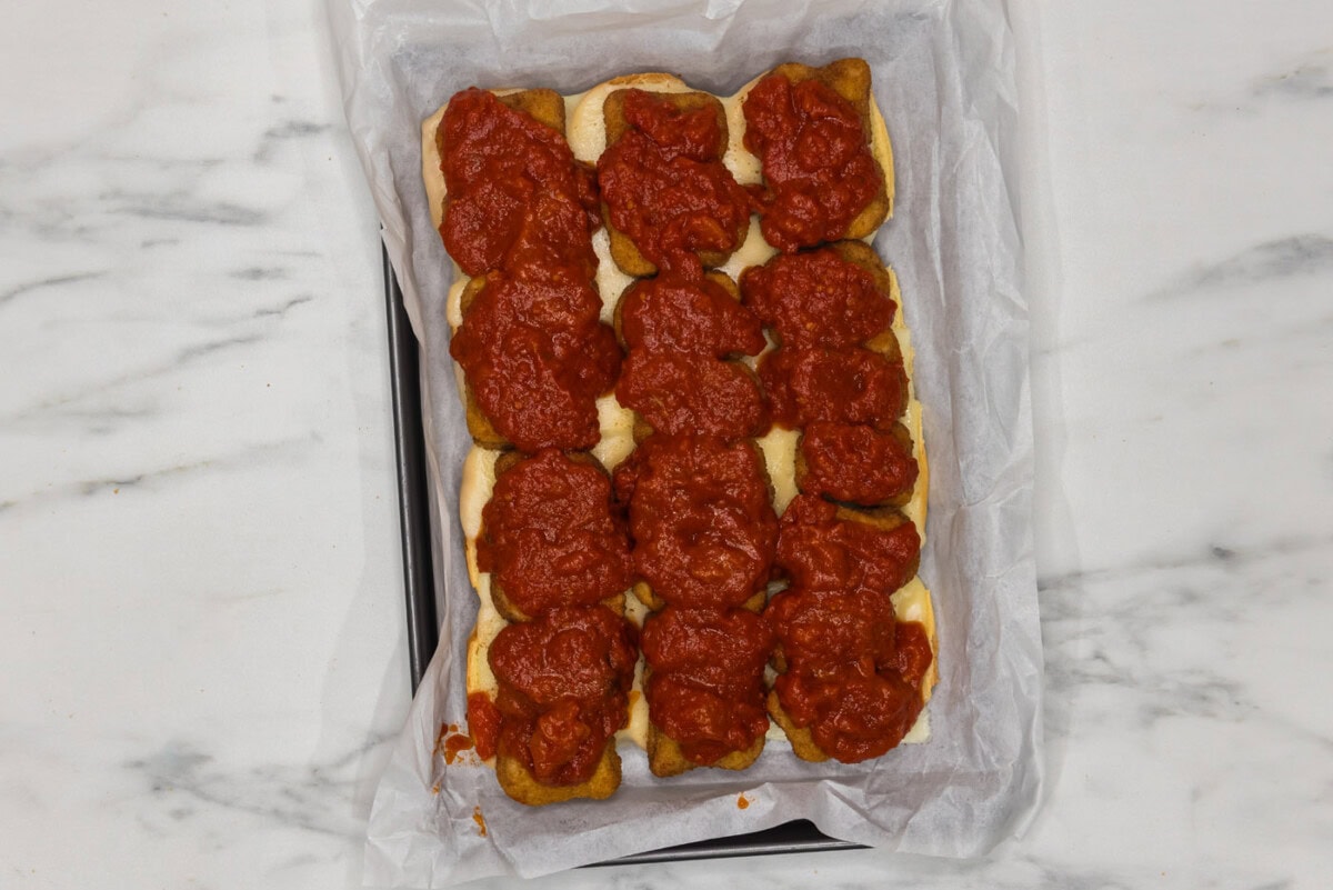 marinara sauce added on top of chicken nuggets and cheese