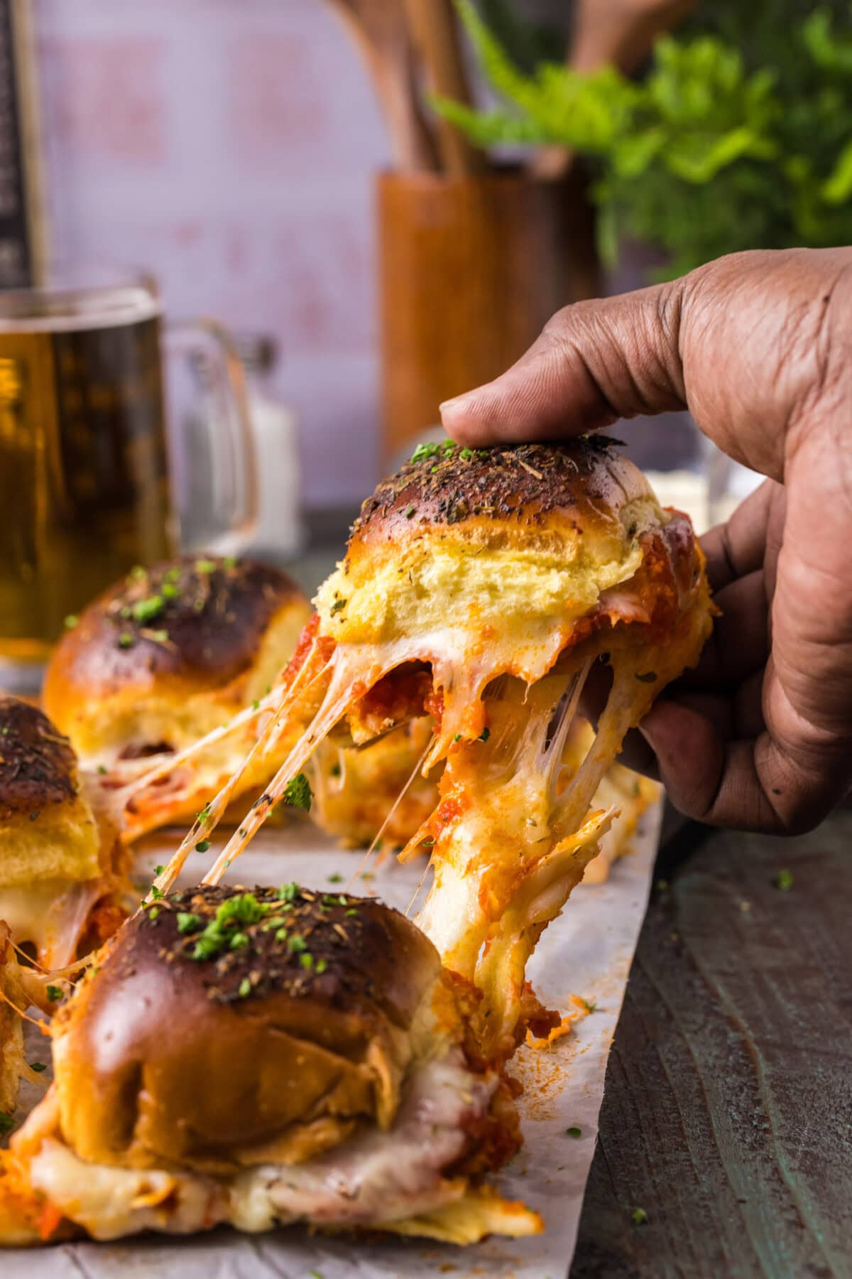Hand pulling up a Chicken Parmesan Slider 