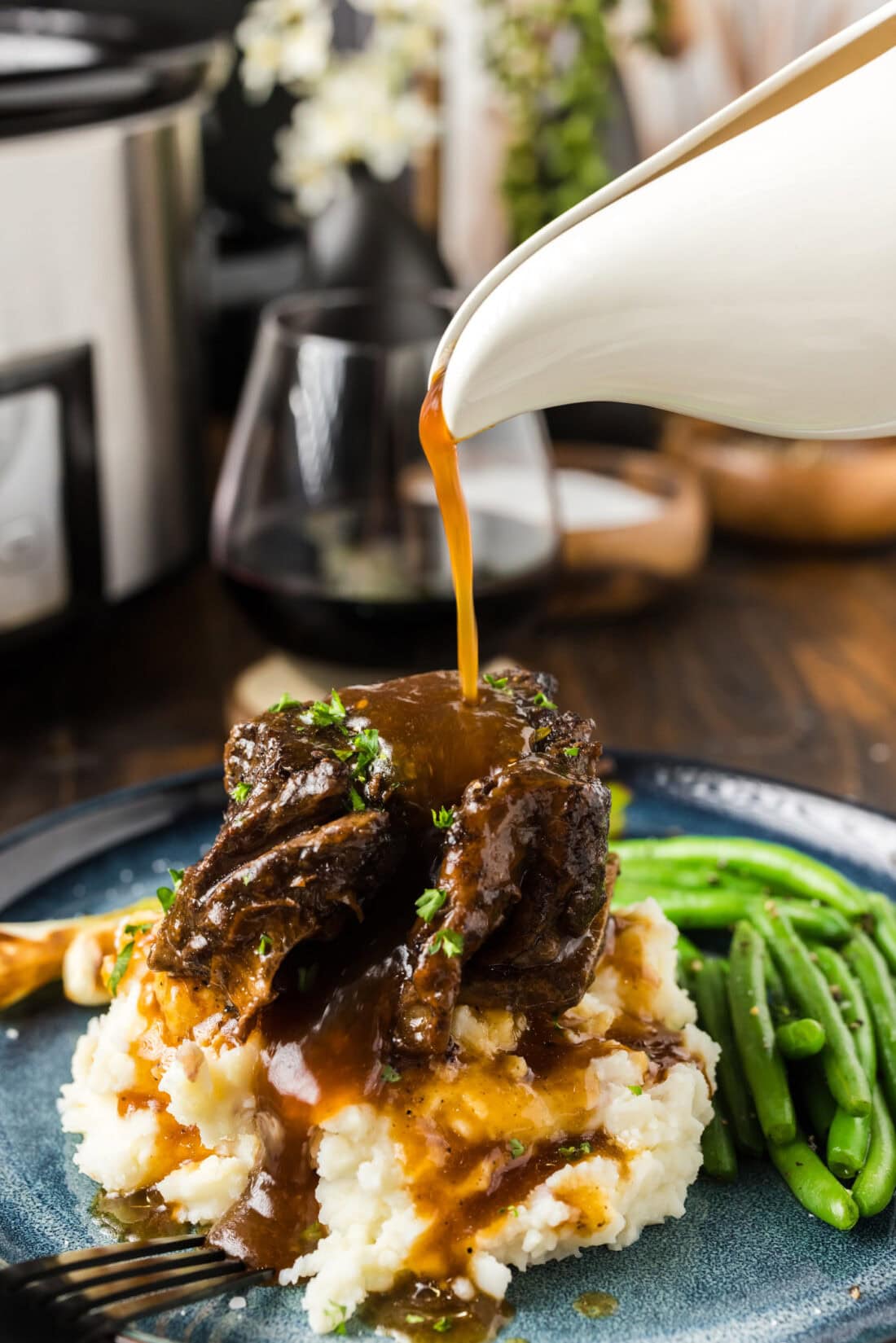 Gravy being poured over a Crockpot Beef Short Rib