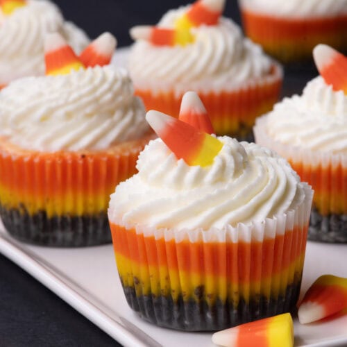 Close up photo of Mini Candy Corn Cheesecakes on a white platter