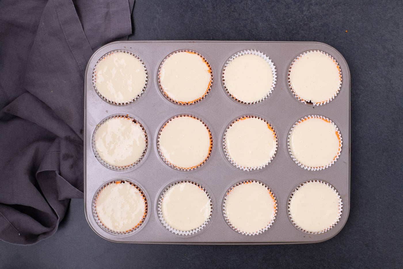 vanilla cheesecake batter in a cupcake pan