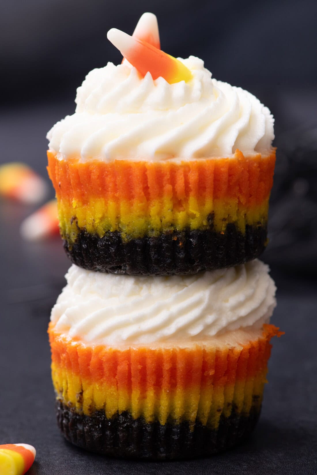 Two Mini Candy Corn Cheesecakes stacked on top of each other