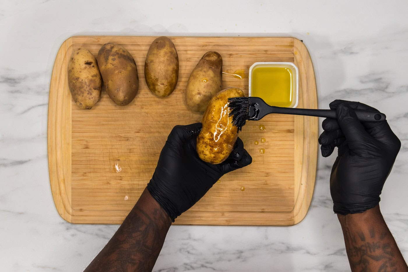 brushing russet potato skin with olive oil