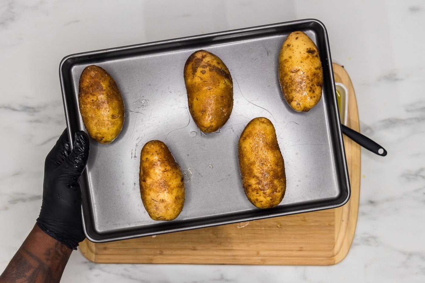 russet potatoes face down on a baking sheet