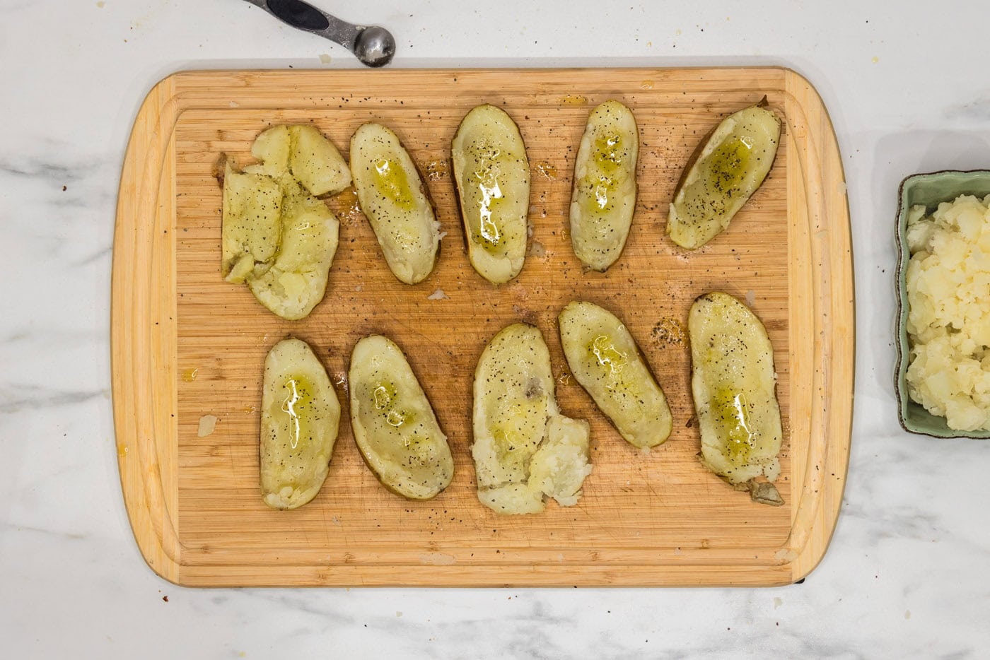 potato skins on a cutting board seasoned with salt and pepper