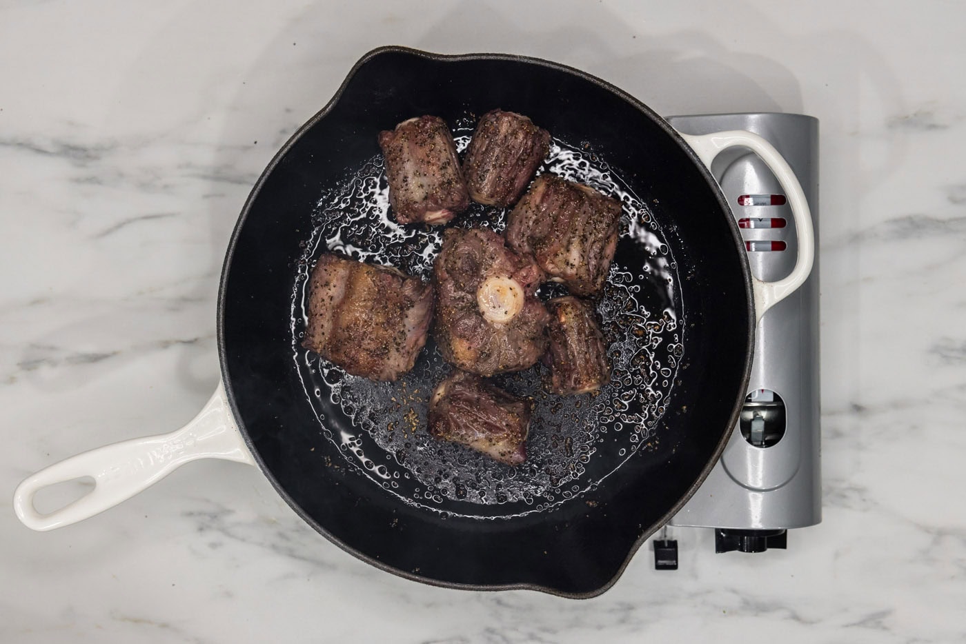 browned oxtail in a skillet