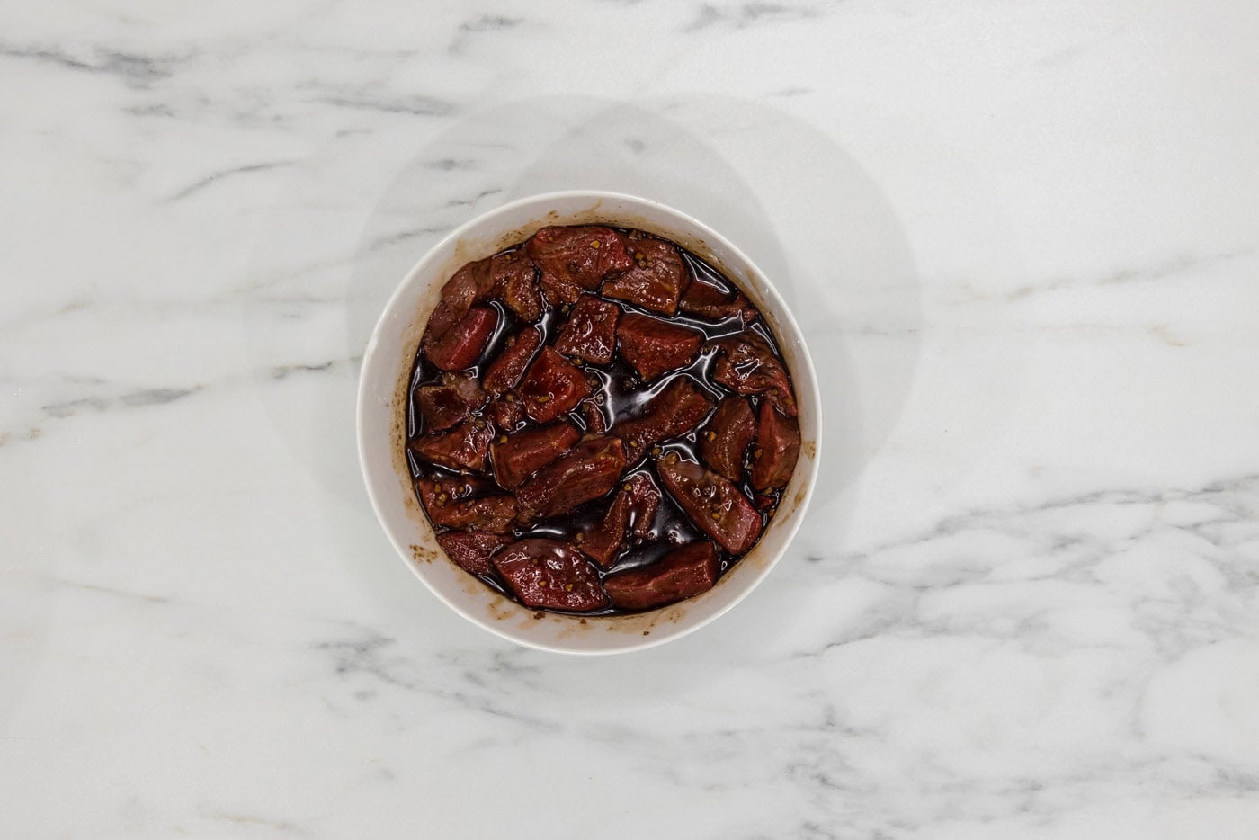 steak marinating in a bowl