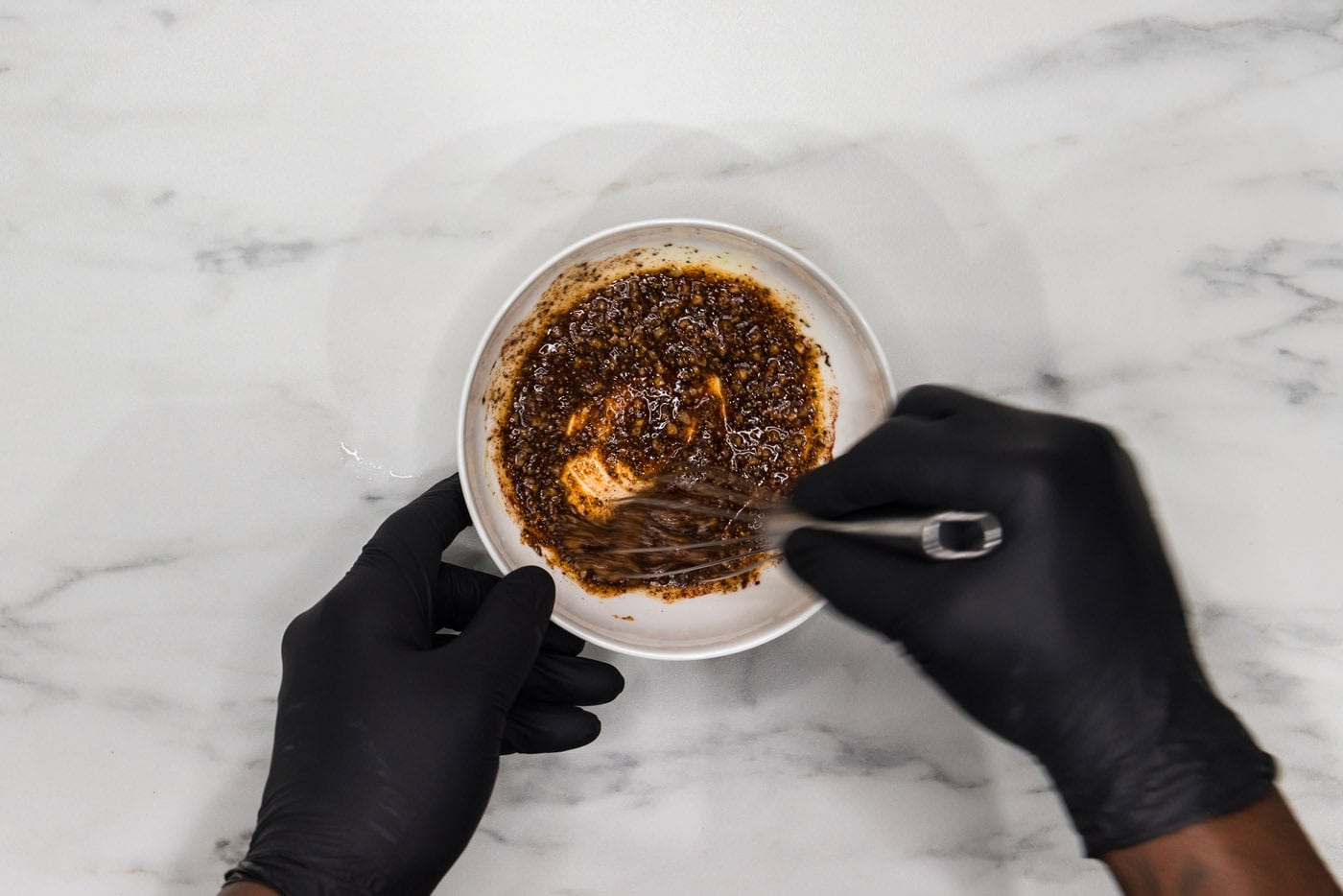 whisking olive oil with seasoning blend in a bowl