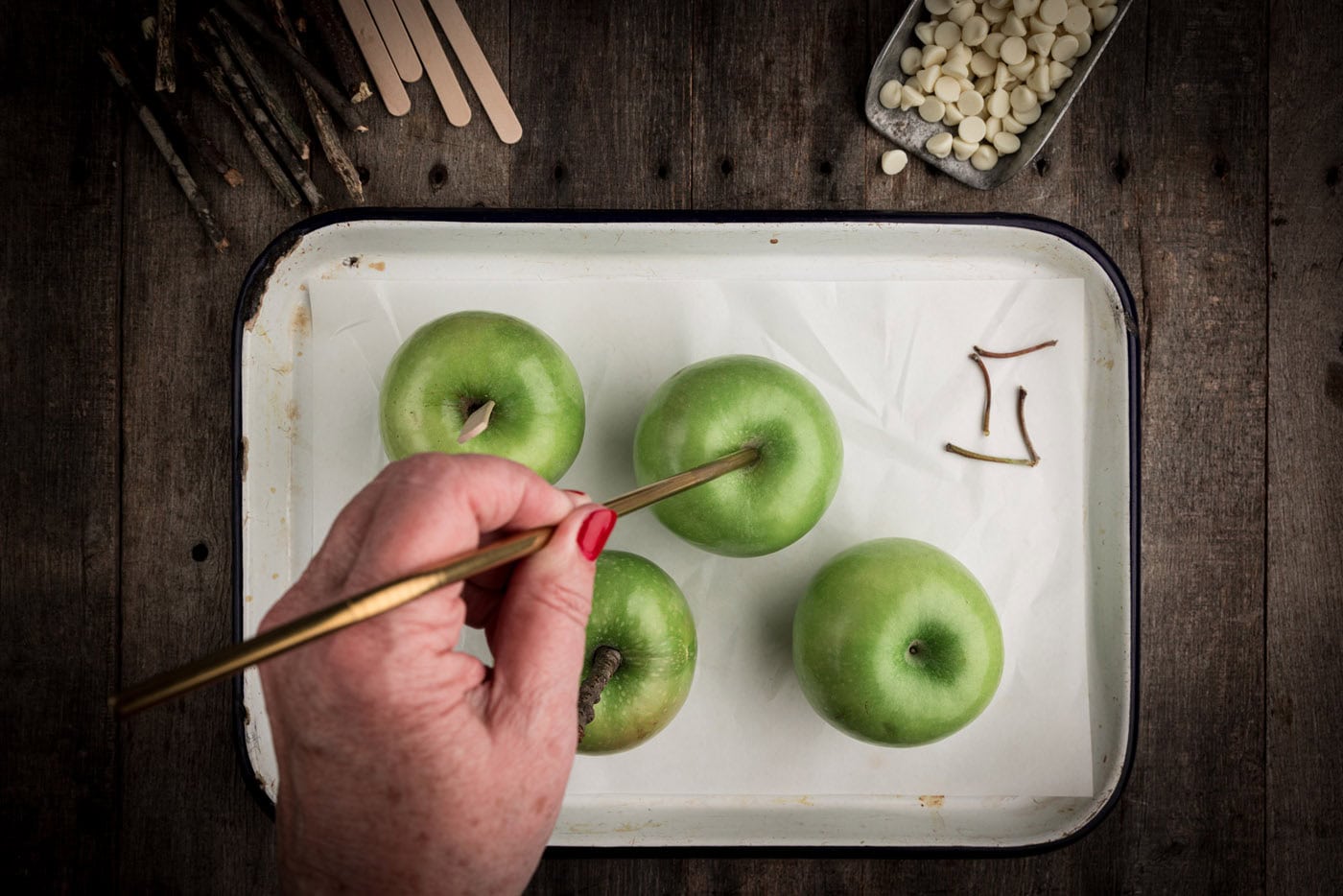 poking a stick through the top of an apple