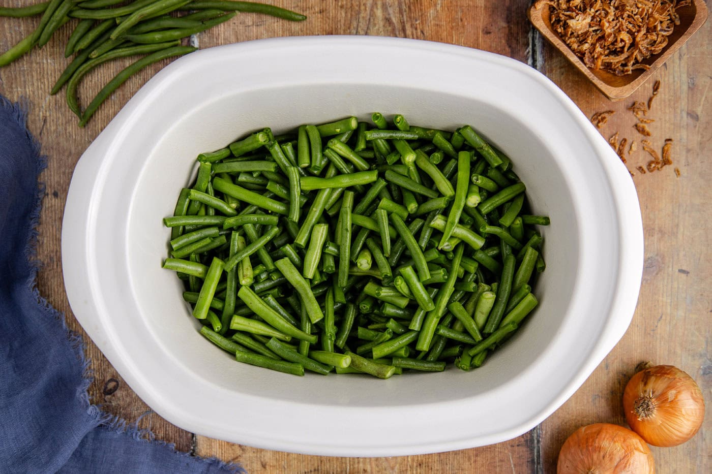 trimmed green beans in a slow cooker crock