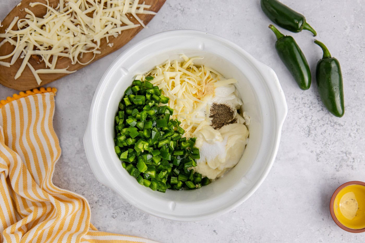 chopped jalapenos, mayo, sour cream, shredded cheese, and cream cheese in a slow cooker crock