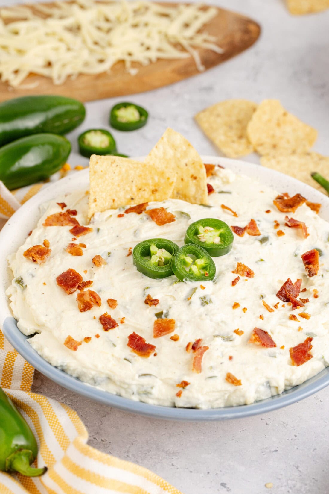 Close up photo of a bowl of Crockpot Jalapeno Popper Dip with two chips stuck in it