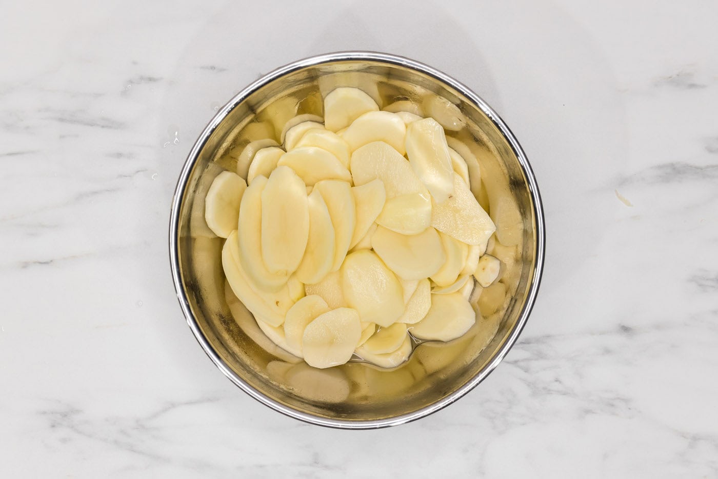 thinly sliced potatoes in a bowl