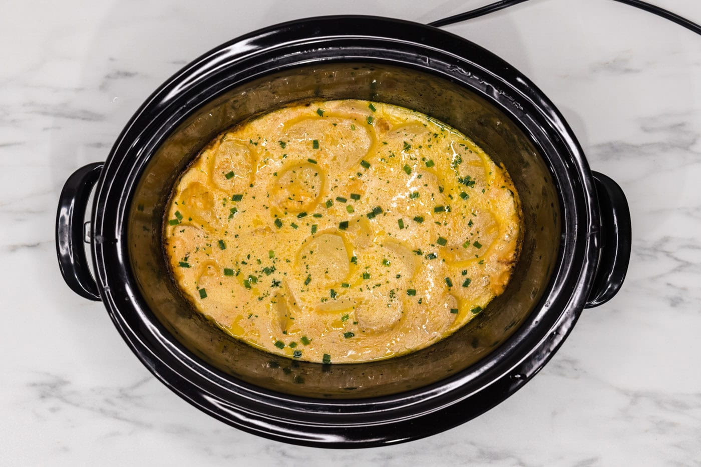 overhead shot of cheesy crockpot scalloped potatoes