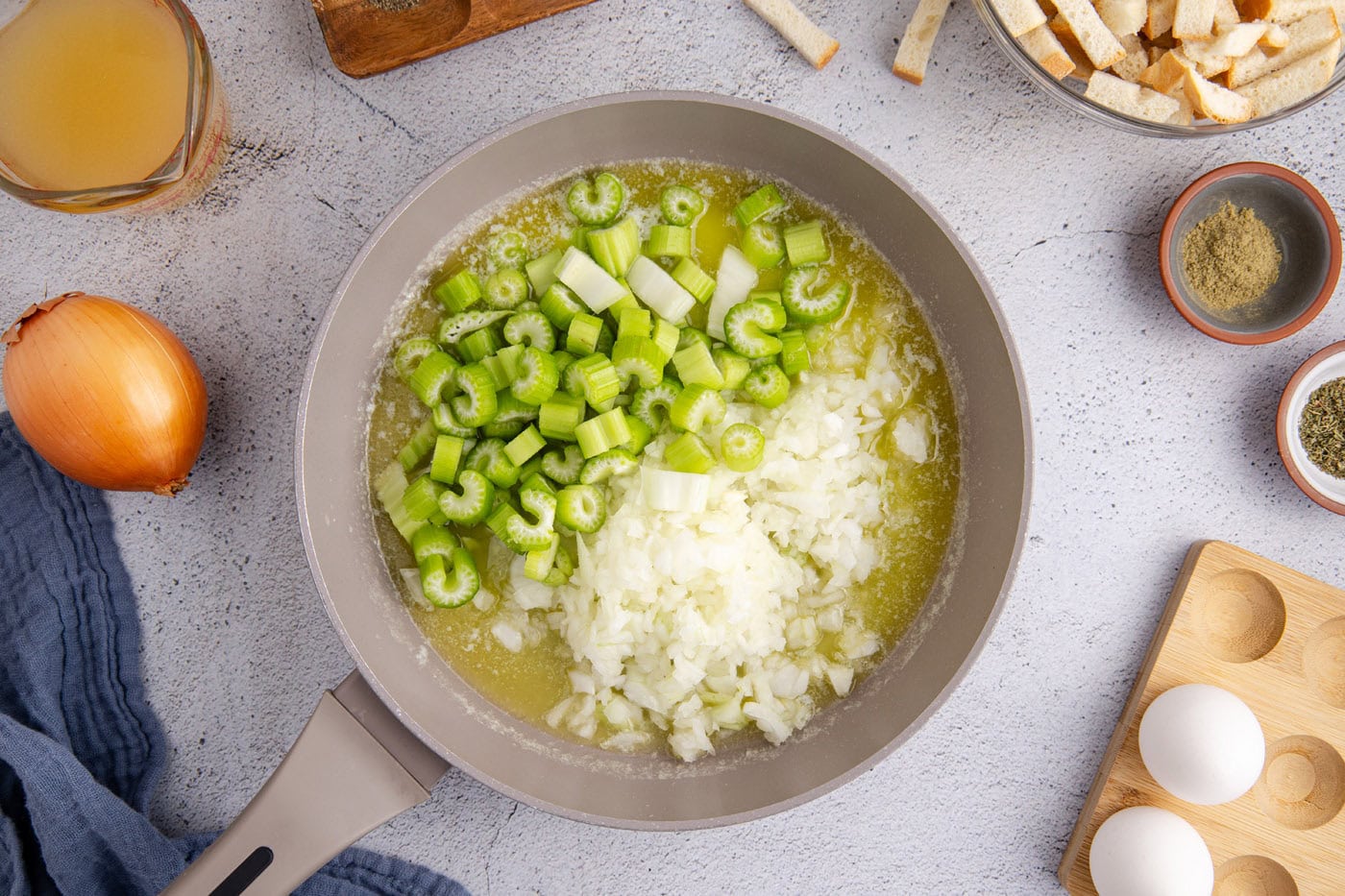 celery and onions cooking in a skillet of butter