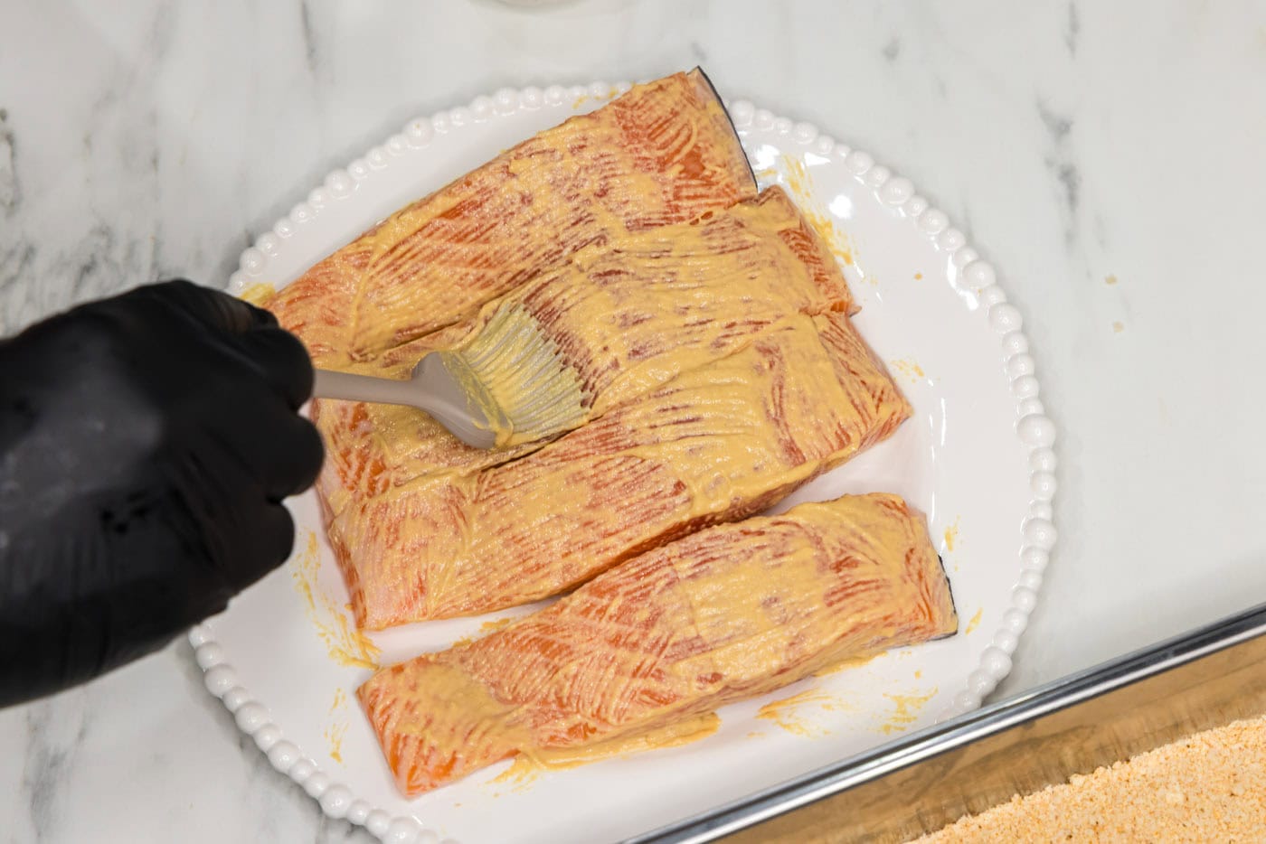 brushing salmon filets with dijon mustard