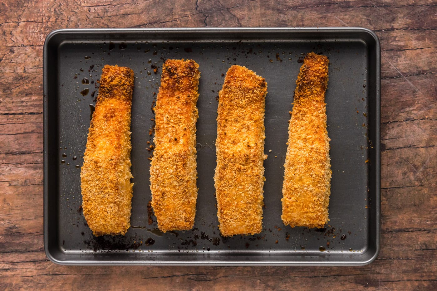 baked crusted salmon filets on a baking sheet