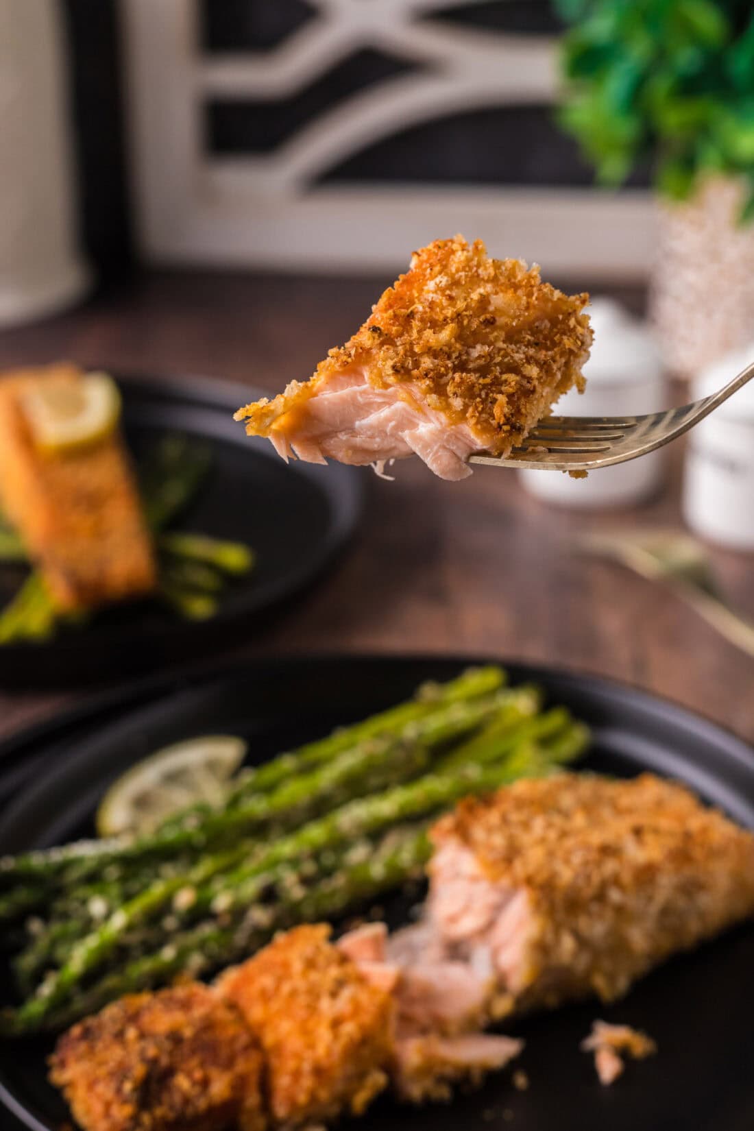 Piece of Crusted Salmon on a fork held above a plate of Crusted Salmon