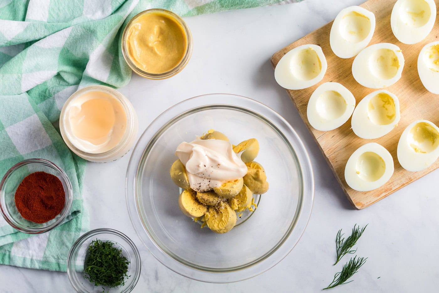 Egg yolks, mayonnaise, mustard, salt, and pepper in a bowl