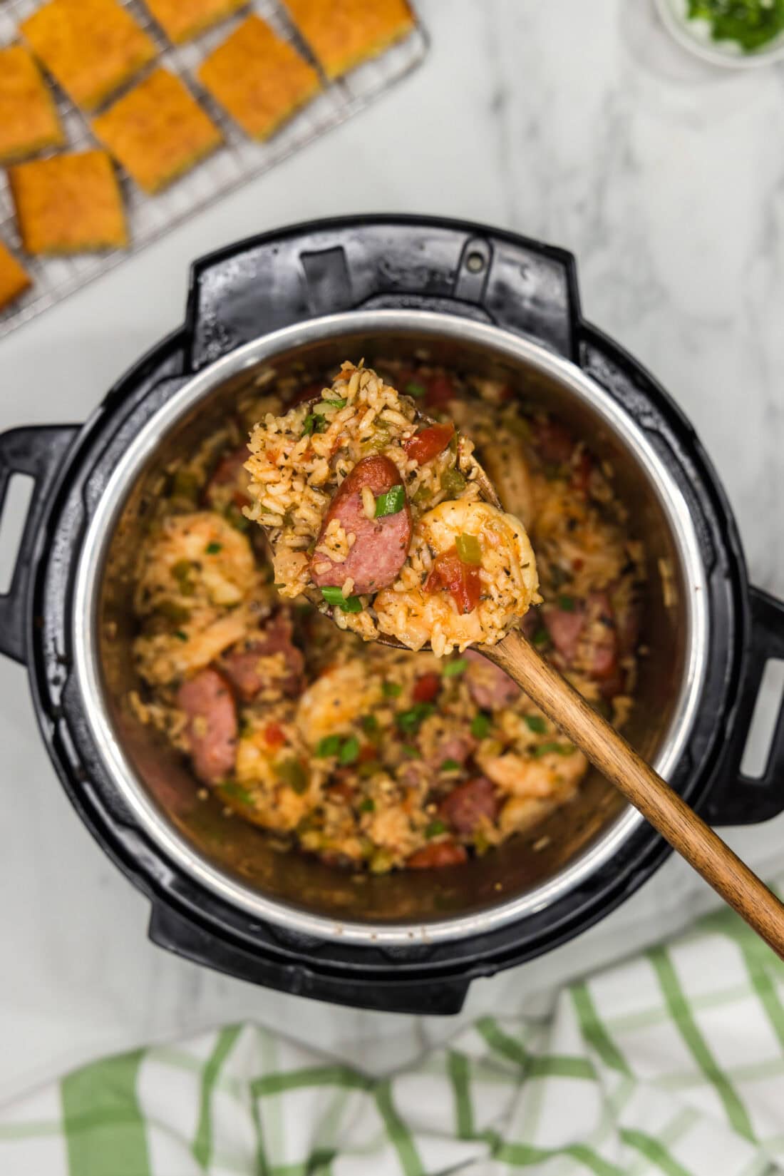 Heaping spoonful of Instant Pot Jambalaya held above an Instant Pot