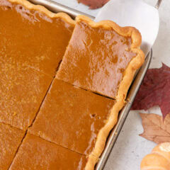 Pumpkin Slab Pie cut into squares with a spatula removing a piece