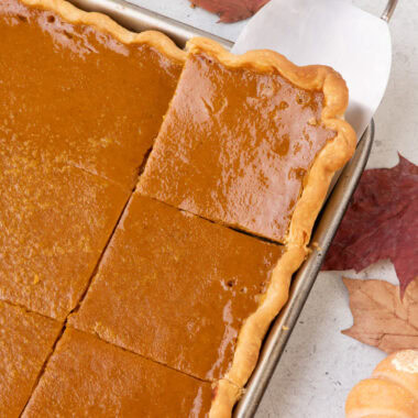 Pumpkin Slab Pie cut into squares with a spatula removing a piece