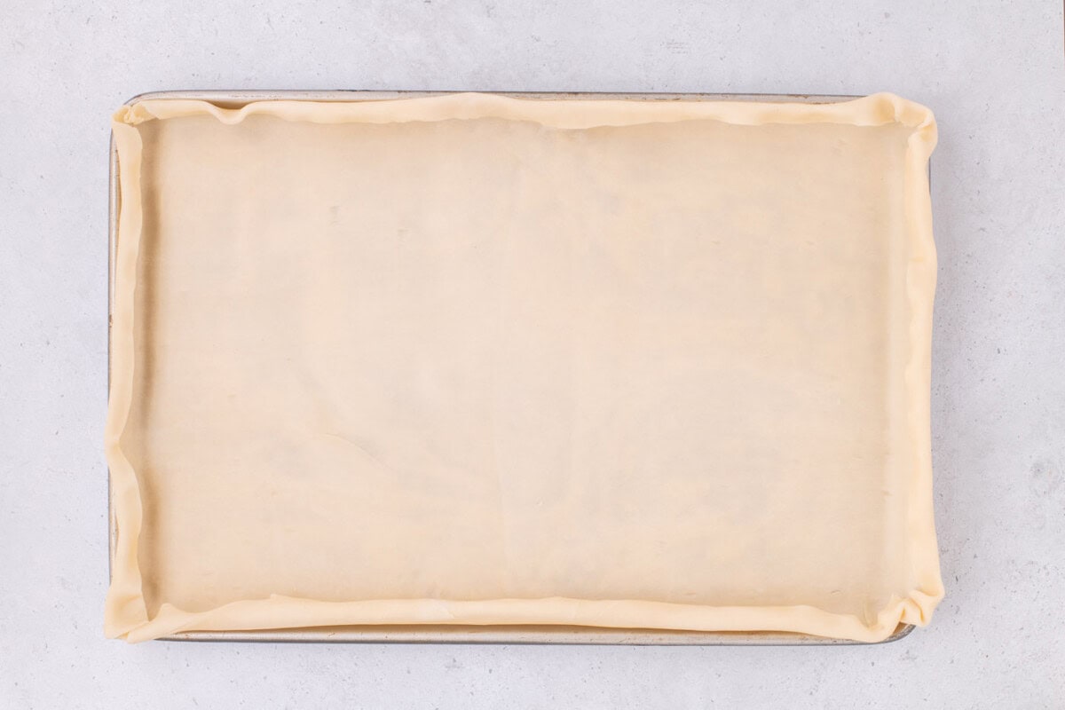 pie dough folded over edges of jelly roll pan