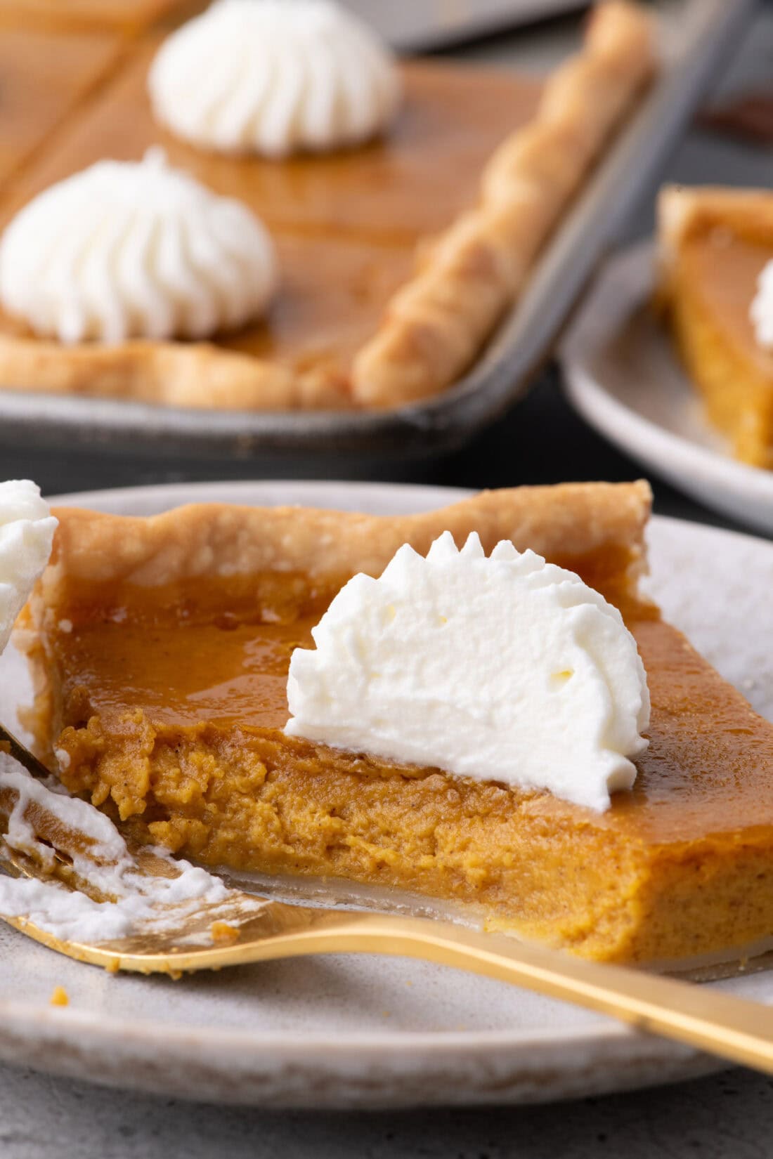 Slice of Pumpkin Slab Pie on a plate with a bite removed