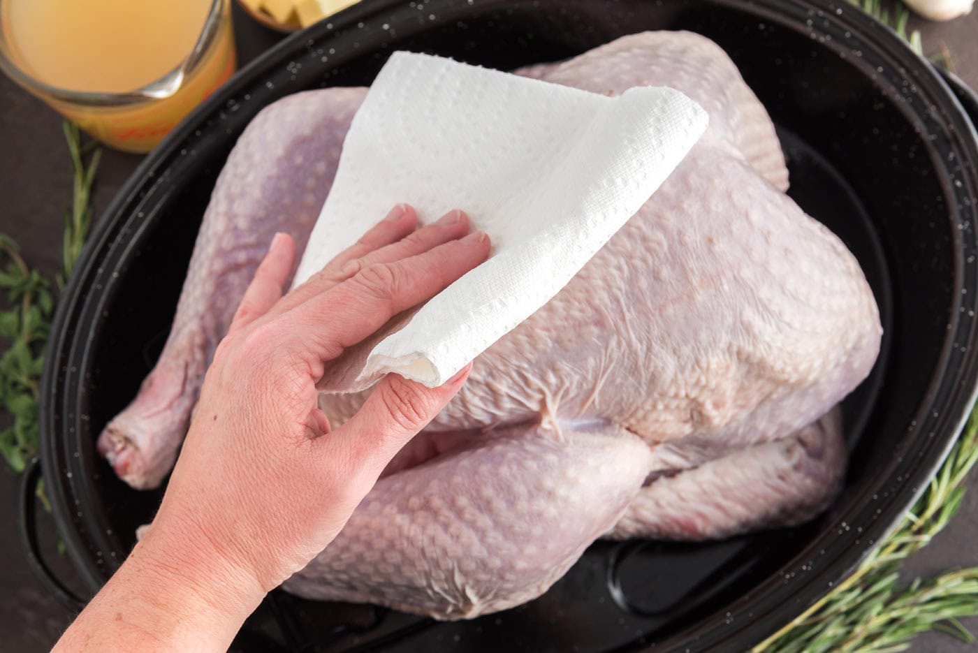 patting turkey dry with a paper towel