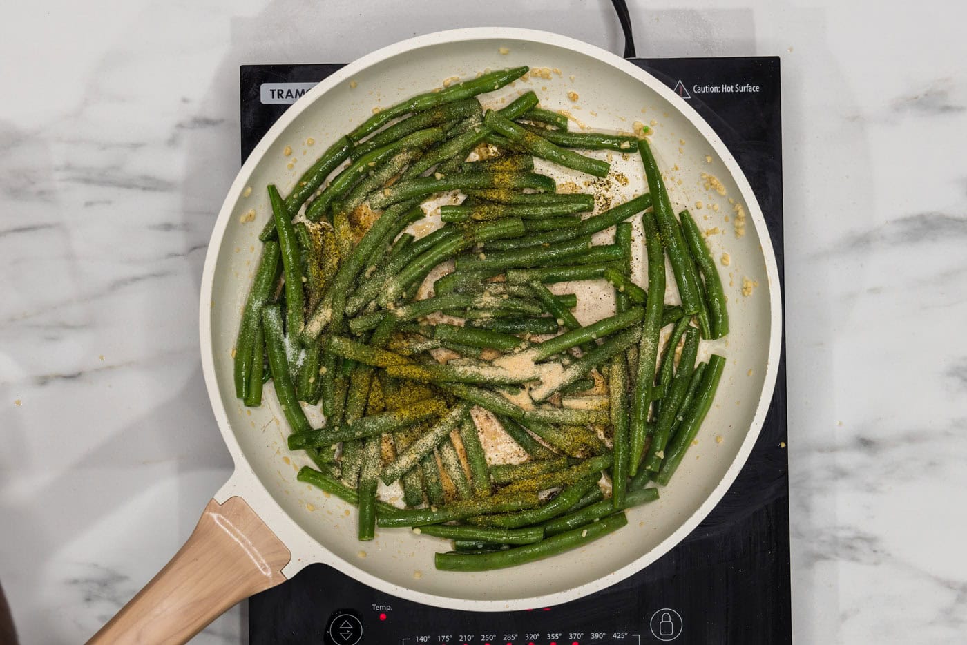 green beans in a skillet with sesame oil and seasonings