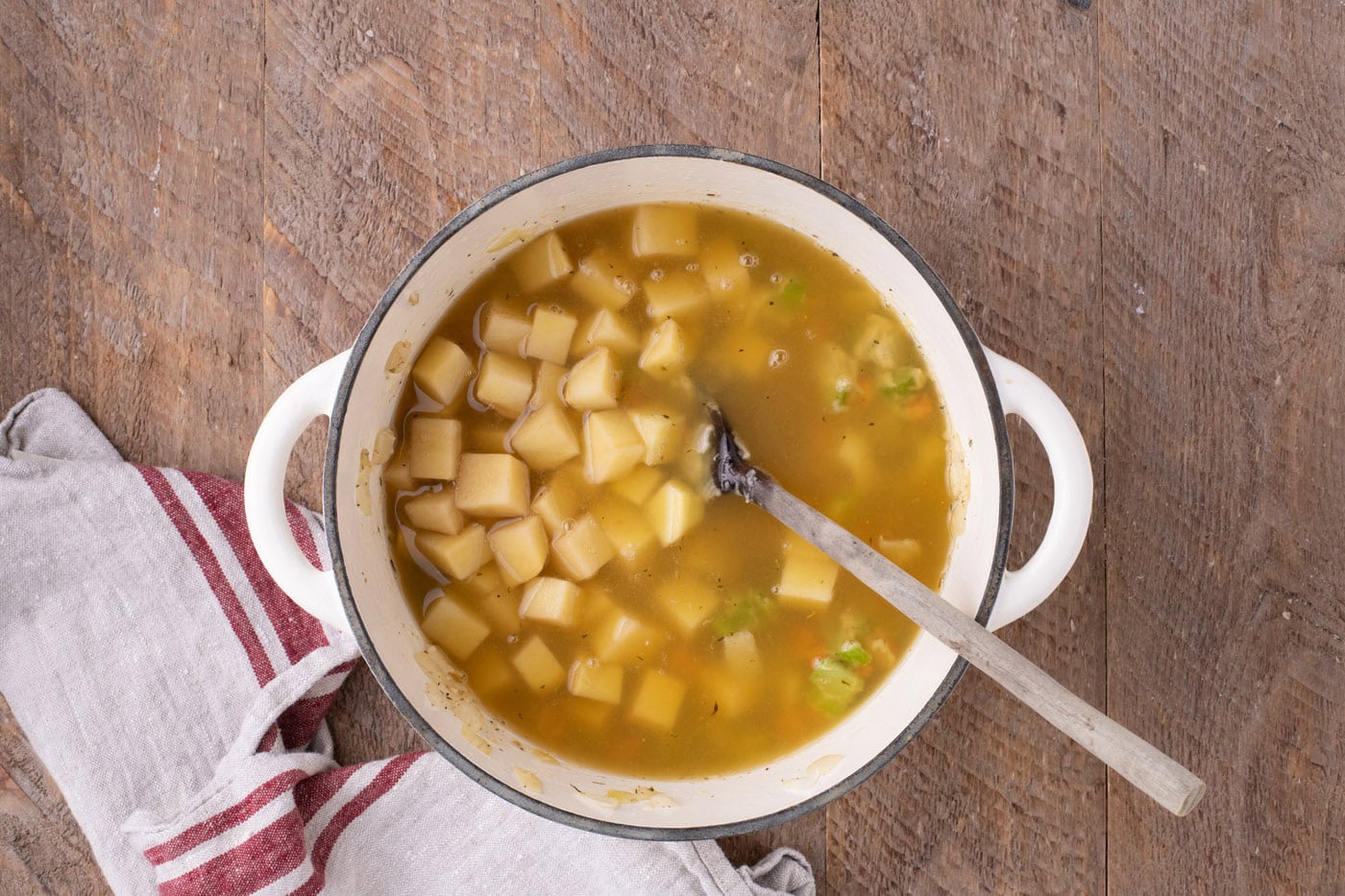 potatoes and chicken broth added to pot with vegetables