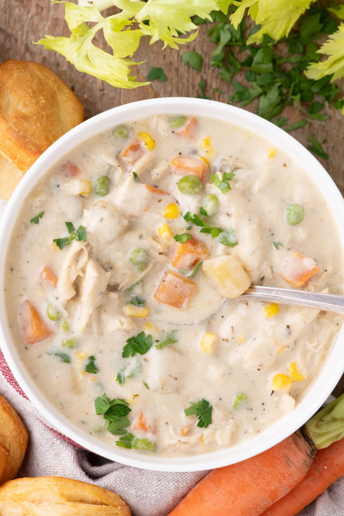 Close up photo of a bowl of Chicken Pot Pie Soup with veggies on the side