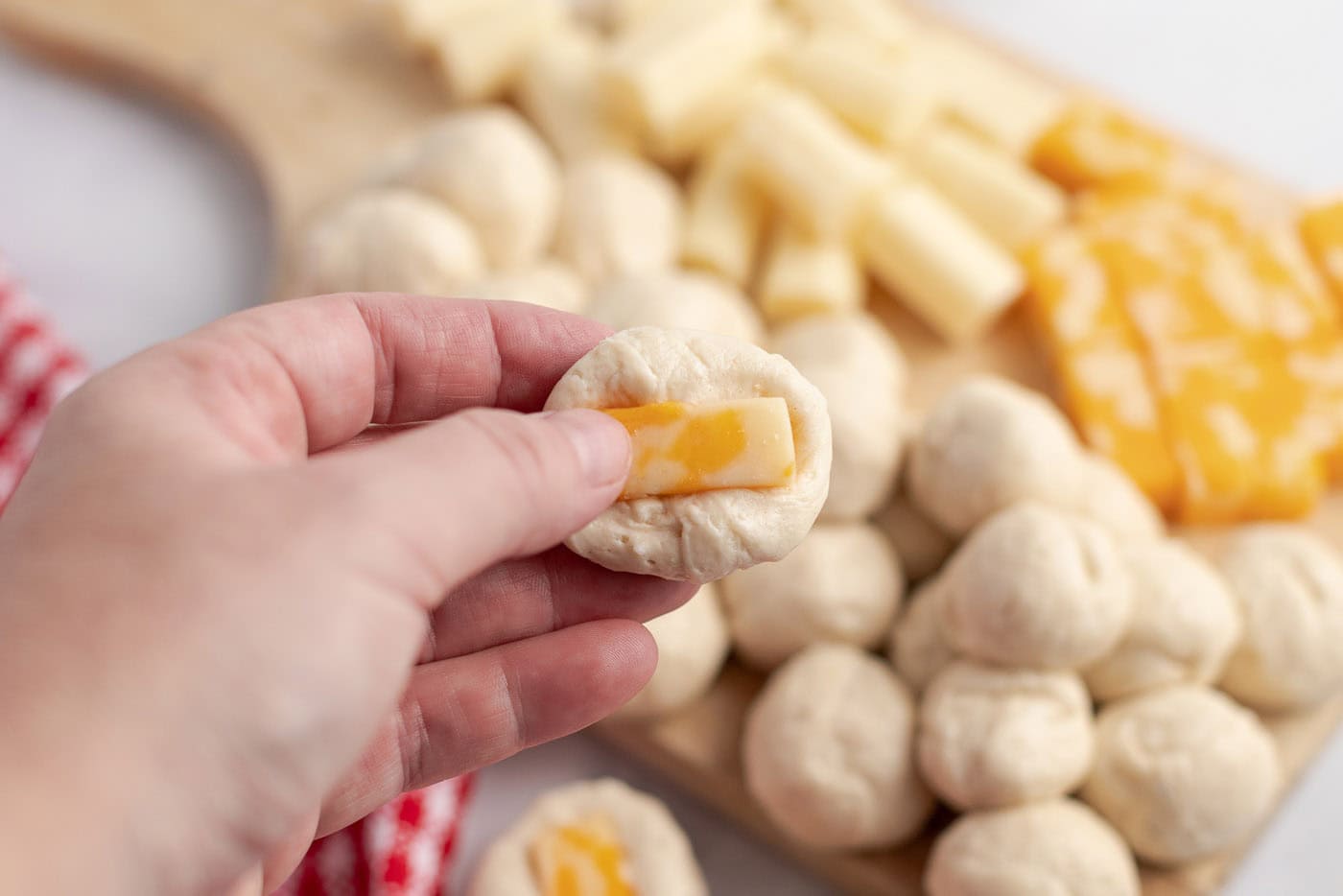 Cheese being pushed into a dough ball