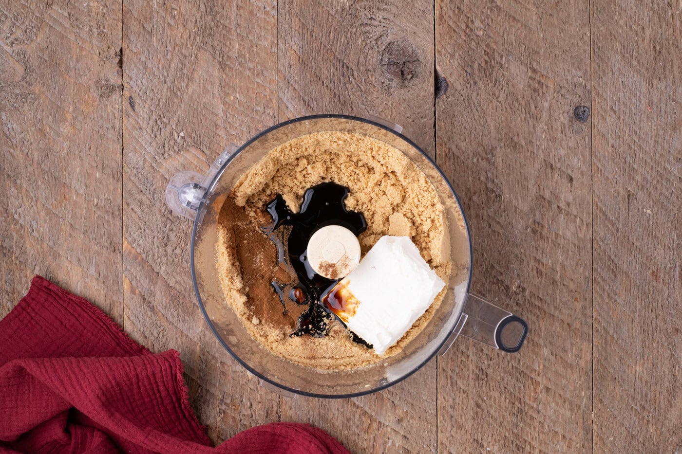 overhead of crushed golden Oreos with cream cheese, spices, and molasses in a food processor