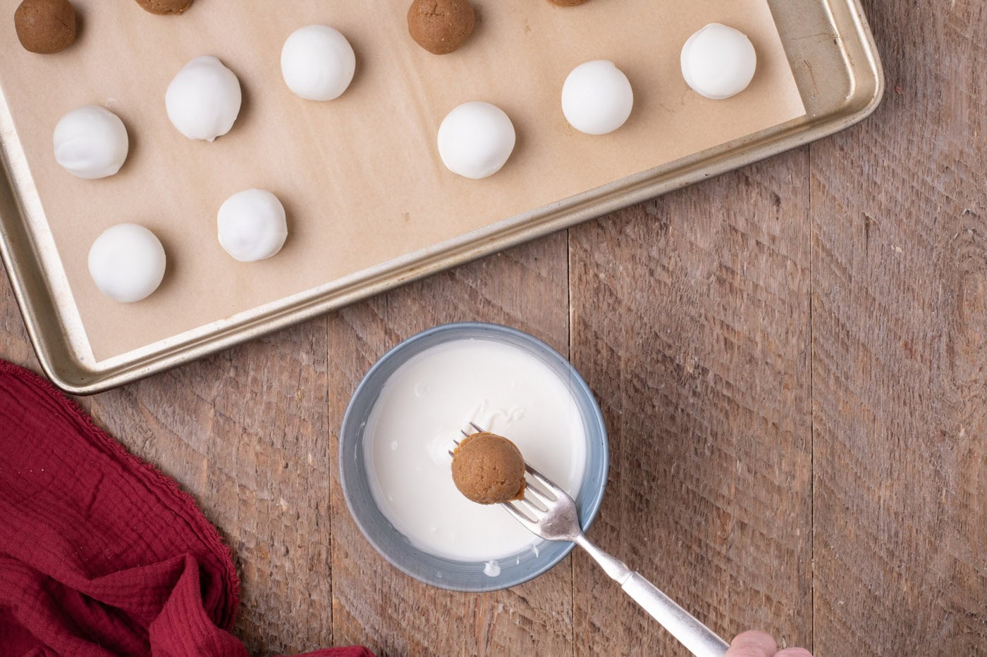 dipping gingerbread truffles into white chocolate with a fork