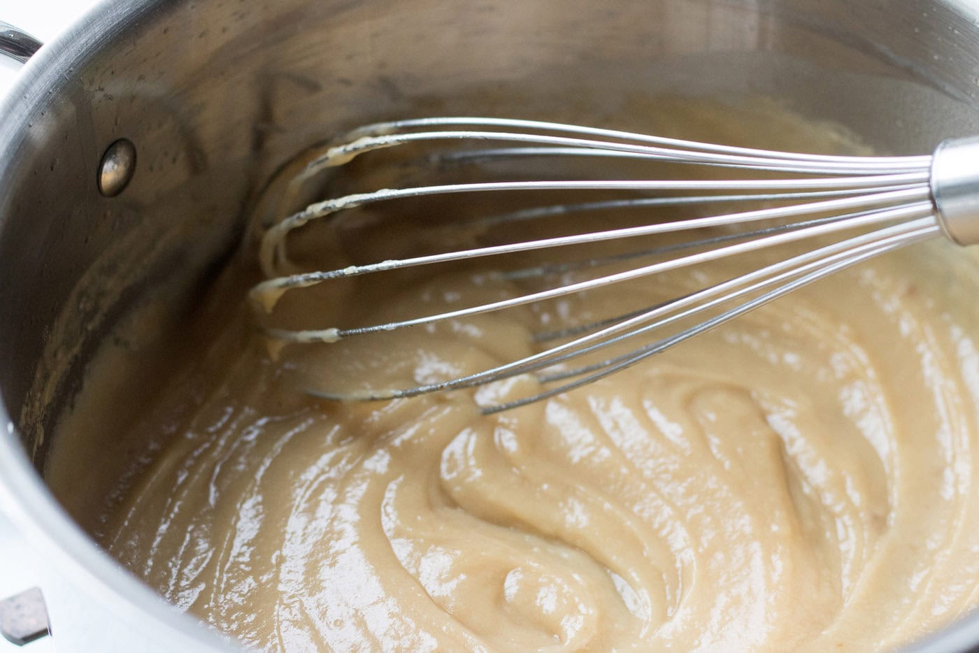 Whisk mixing a saucepan of fat and flour