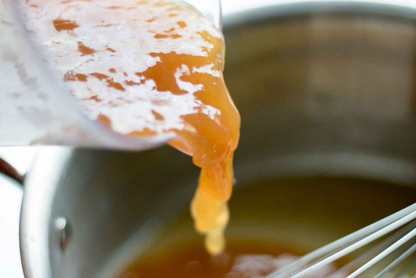 Pan drippings being added into a saucepan