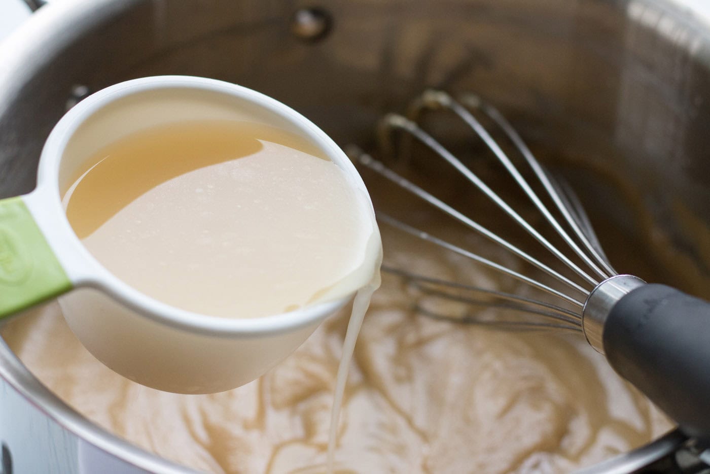 Broth being added into a saucepan