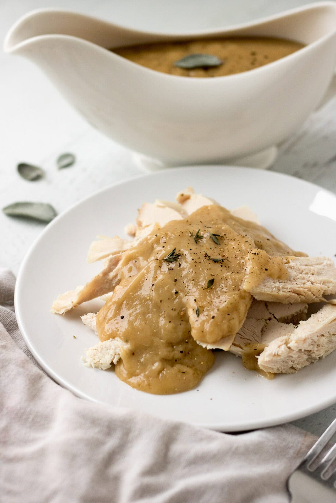 Homemade Turkey Gravy over sliced turkey on a plate