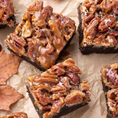 Pecan Pie Brownies on parchment paper topped with caramel