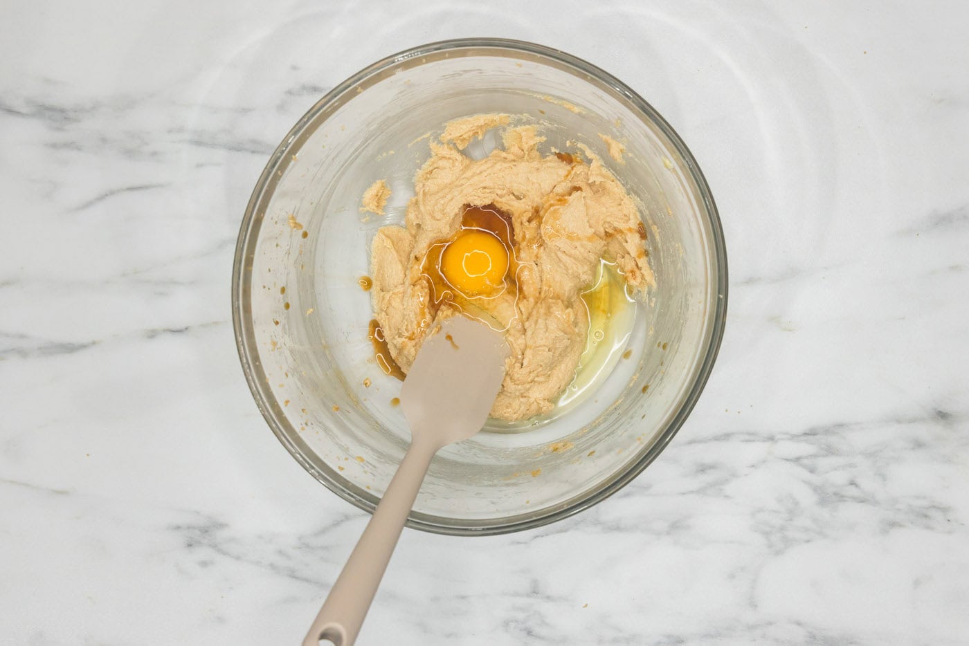 rubber spatula in a bowl with egg and butter and sugar mixture