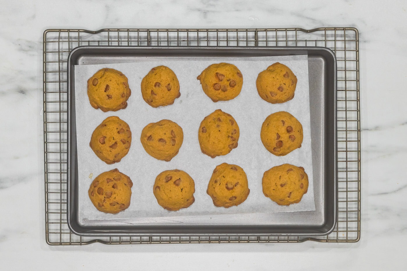 baked pumpkin cinnamon chip cookies on a baking sheet