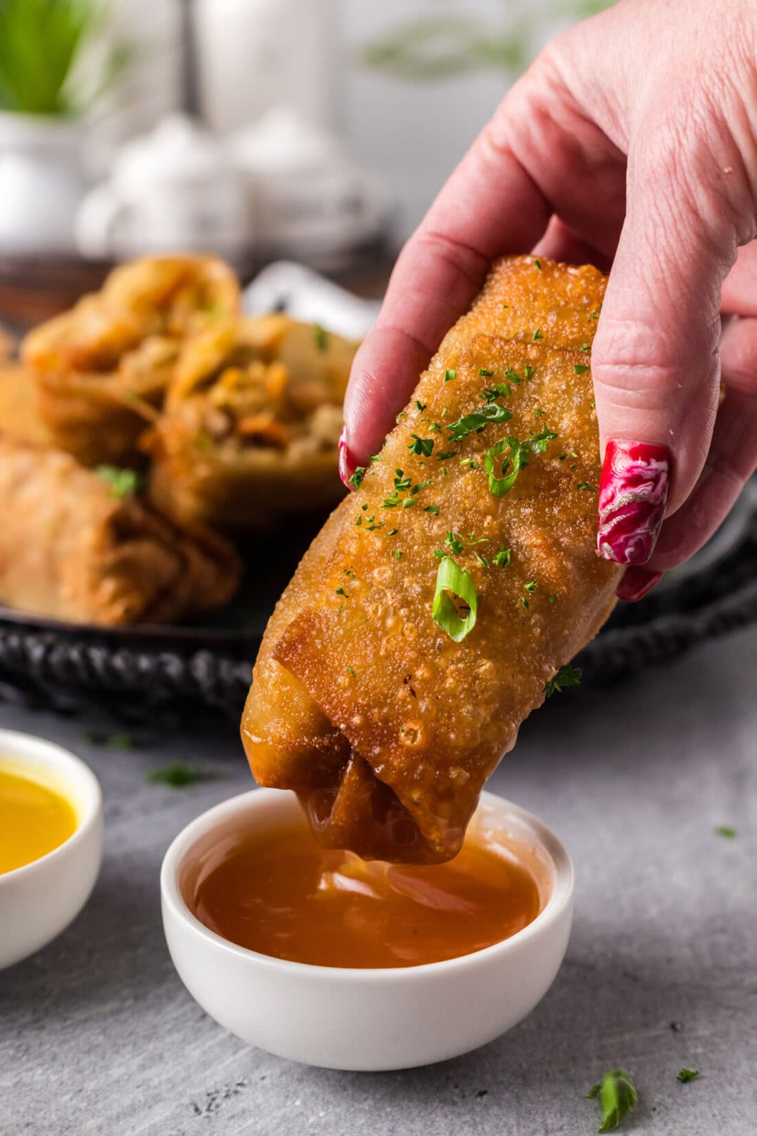 Shrimp Egg Roll being dipped into sauce