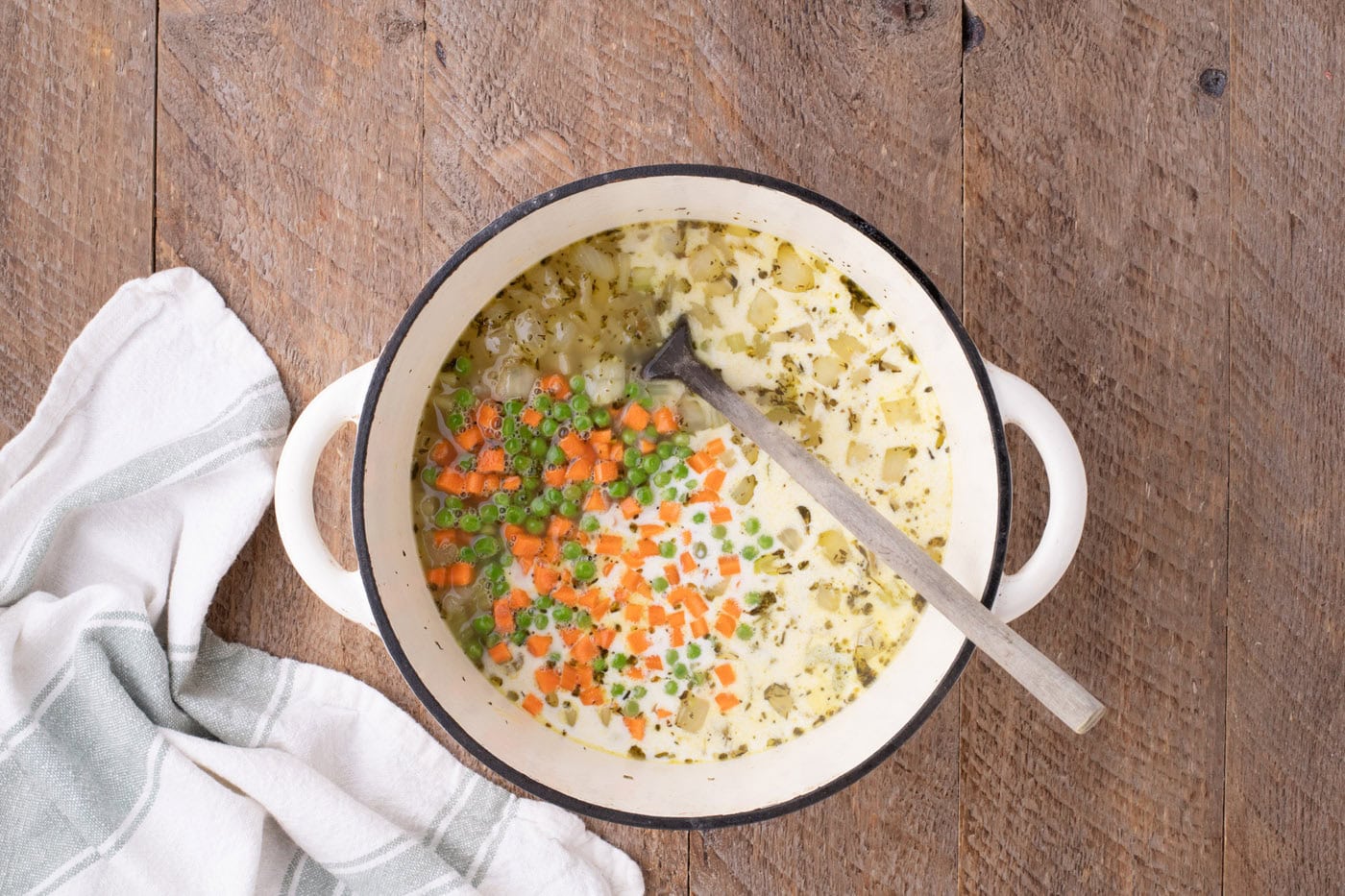 carrots, peas, and heavy cream added to pot with veggies