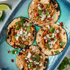 Chicken Tinga on tortillas topped with onions and cilantro